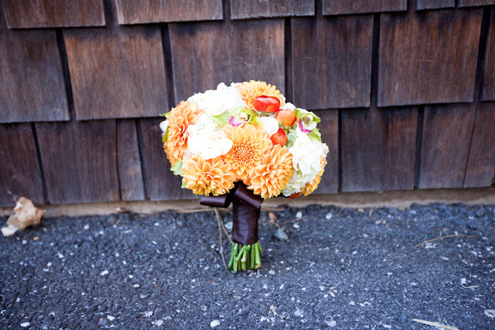 The bridal bouquet composes of bright orange dahlias white gardenias